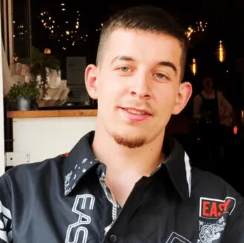 Man in vrijetijdskleding glimlacht in een restaurant